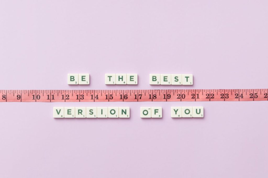 Motivational phrase 'Be the Best Version of You' with a measuring tape on purple background.